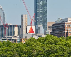 Preview wallpaper skyscraper, construction, trees, city