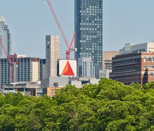 Preview wallpaper skyscraper, construction, trees, city