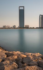 Preview wallpaper skyscraper, sea, stones, coast, city, abu dhabi, uae