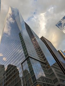 Preview wallpaper skyscrapers, buildings, sky, clouds, glass, reflection