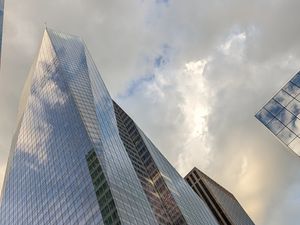 Preview wallpaper skyscrapers, buildings, sky, clouds, glass, reflection