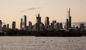 Preview wallpaper skyscrapers, buildings, trees, river, sunrise, city