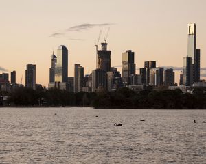 Preview wallpaper skyscrapers, buildings, trees, river, sunrise, city