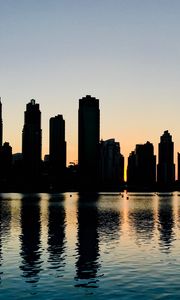 Preview wallpaper skyscrapers, city, buildings, water, silhouette, glare