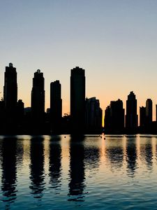 Preview wallpaper skyscrapers, city, buildings, water, silhouette, glare