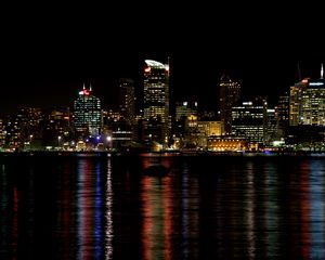 Preview wallpaper skyscrapers, lights, night, sea, boat, city