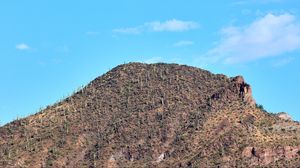 Preview wallpaper slope, mountain, rocks, bushes, sky