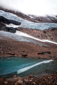 Preview wallpaper slope, rock, snow, pebbles, water