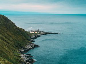 Preview wallpaper slope, rocks, sea, buildings, horizon