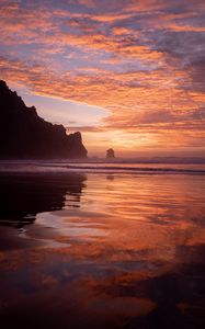 Preview wallpaper slope, rocks, sunset, sea, clouds, reflection