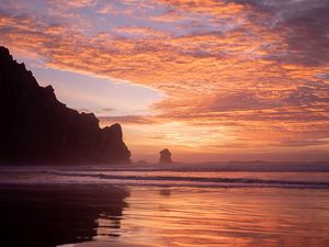 Preview wallpaper slope, rocks, sunset, sea, clouds, reflection