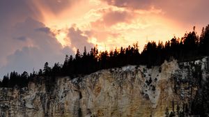 Preview wallpaper slope, trees, sunset, rocks, clouds