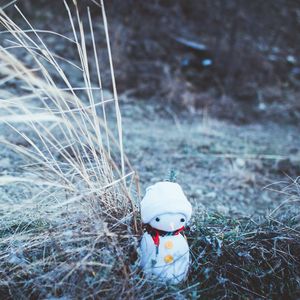Preview wallpaper snowman, christmas, new year, toy, grass, blur