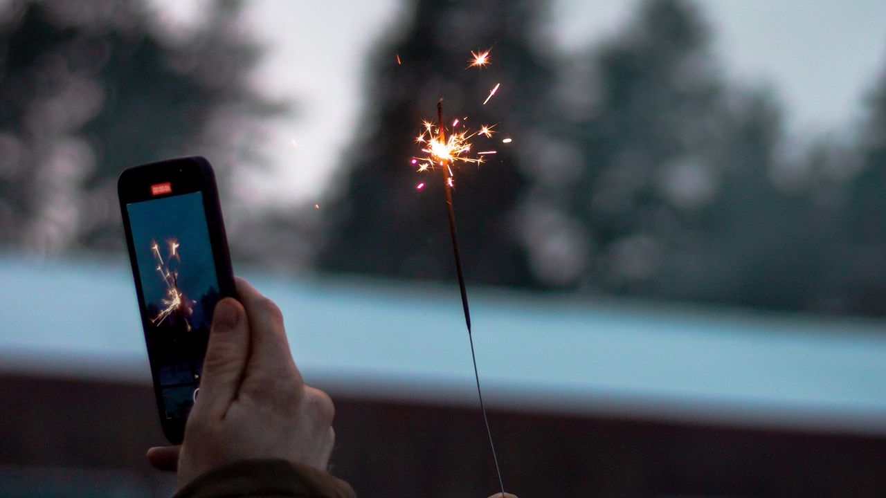 Wallpaper sparkler, hand, phone, sparks