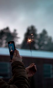 Preview wallpaper sparkler, hand, phone, sparks