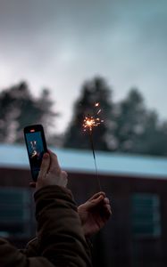 Preview wallpaper sparkler, hand, phone, sparks