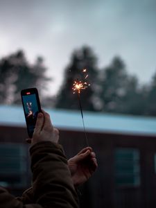 Preview wallpaper sparkler, hand, phone, sparks