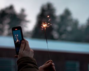 Preview wallpaper sparkler, hand, phone, sparks