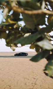 Preview wallpaper sports car, car, sand, branches, leaves