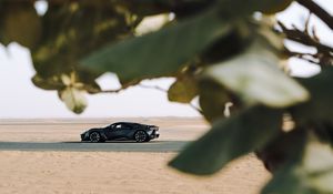 Preview wallpaper sports car, car, sand, branches, leaves