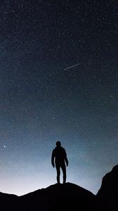 Preview wallpaper starry sky, silhouette, man, rocks