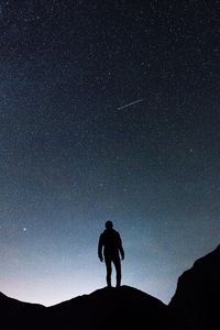 Preview wallpaper starry sky, silhouette, man, rocks