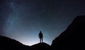 Preview wallpaper starry sky, silhouette, man, rocks