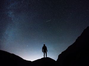 Preview wallpaper starry sky, silhouette, man, rocks