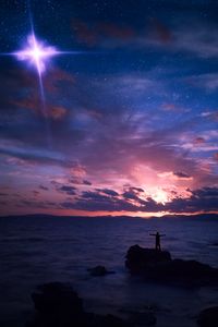 Preview wallpaper starry sky, silhouette, rock, sea, horizon, night