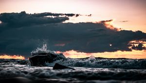 Preview wallpaper stone, spray, clouds, sunset, sea