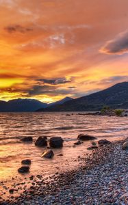 Preview wallpaper stones, coast, sea, blocks, orange, decline, sky, clouds, veil, shades, structure