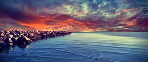 Preview wallpaper stones, construction, sea, breakwater, water, bottom, stains, small, clouds, evening, decline, horizon