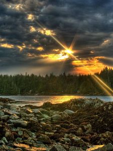 Preview wallpaper stones, evening, sun, beams, clouds, wood, lake, cloudy