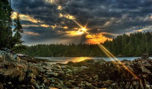 Preview wallpaper stones, evening, sun, beams, clouds, wood, lake, cloudy