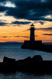 Preview wallpaper stones, lighthouse, silhouette, sea, twilight