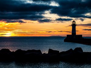 Preview wallpaper stones, lighthouse, silhouette, sea, twilight