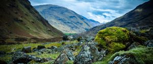 Preview wallpaper stones, moss, mountains, hollow, sky, cloudy