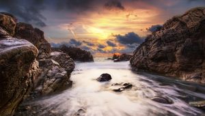 Preview wallpaper stones, rocks, stream, water, sea, sky, clouds, orange, gleam