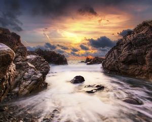 Preview wallpaper stones, rocks, stream, water, sea, sky, clouds, orange, gleam