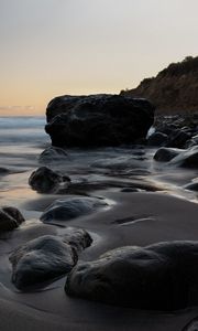 Preview wallpaper stones, sand, water, wet, coast, sea, twilight