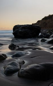 Preview wallpaper stones, sand, water, wet, coast, sea, twilight