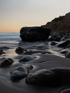 Preview wallpaper stones, sand, water, wet, coast, sea, twilight