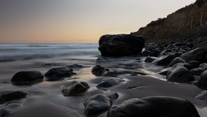 Preview wallpaper stones, sand, water, wet, coast, sea, twilight