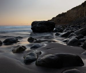 Preview wallpaper stones, sand, water, wet, coast, sea, twilight