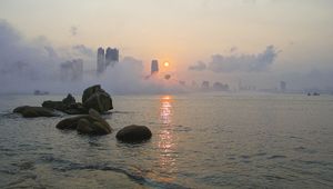 Preview wallpaper stones, sea, fog, city, sunrise