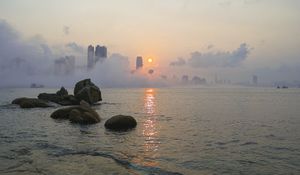 Preview wallpaper stones, sea, fog, city, sunrise