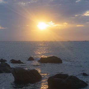 Preview wallpaper stones, sea, glare, sunset