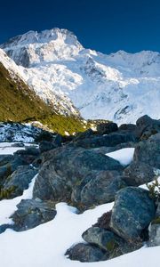 Preview wallpaper stones, snow, mountains, thawed patches, spring, light