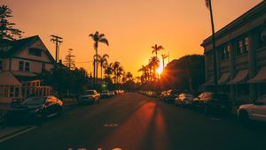 Preview wallpaper street, sunset, palm trees, road, road signs, cars