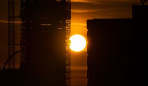 Preview wallpaper sun, buildings, outlines, sunset, dark, building, crane